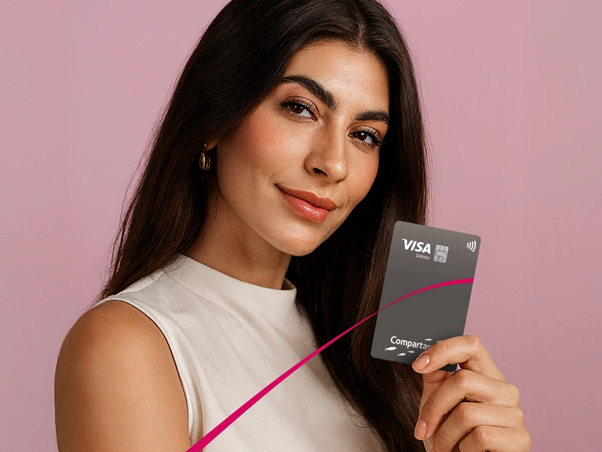 Mujer sonriente sosteniendo tarjeta Compartamos Banco